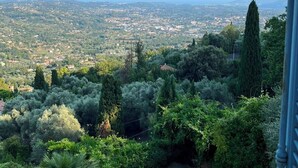 A balcony with a view of a cityscape and surrounding greenery. - Stunning villa with a pool and ocean view, Mediterranean garden, sleeps 8 (Grasse)