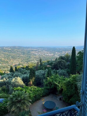 Ein Balkon mit Blick auf eine Stadtlandschaft und grüne Umgebung.