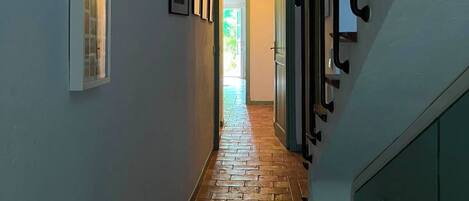 Uma escada com piso de madeira que leva a uma porta no final.