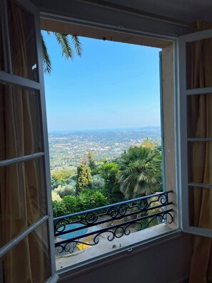 A window with a view of a cityscape and greenery. - Stunning villa with a pool and ocean view, Mediterranean garden, sleeps 8 (Grasse)