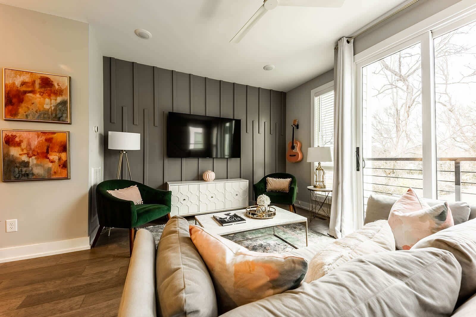 Ein modernes Wohnzimmer mit einer Couch, Sesseln, einem Couchtisch und Kunstwerken an den Wänden.
