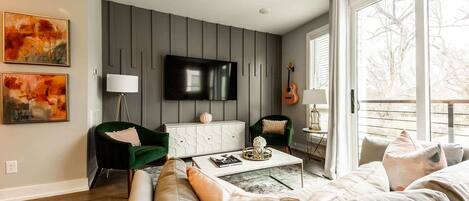 A modern living room with a sofa, chairs, a coffee table, and artwork on the walls.