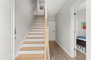 A staircase with wooden steps and white walls, leading to a door at the top. - Nashville Pop Art 4BR, Near Downtown and Sleeps 10 (Nashville)