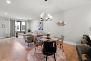 Ein modernes Wohnzimmer mit einem runden Esstisch, Sofas und einem Kicker.