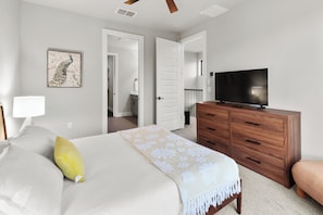A hotel room with a bed, a TV, a wooden dresser, and a door leading to a bathroom. - Cozy 2-bedroom townhome in peaceful Austin with AC (Austin)