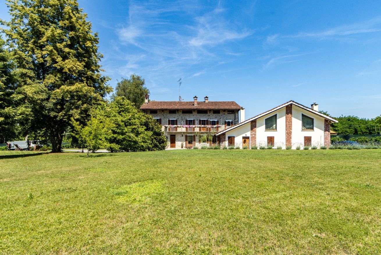 A two-story house with a large lawn in front.