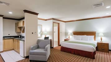 Una habitación de hotel con cama, mesita de noche, lámpara y una silla.