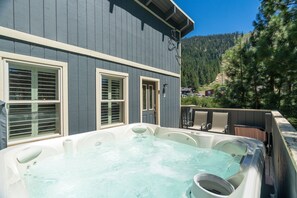 Ein Whirlpoolbereich mit Blick auf einen Berg und einen Wald.