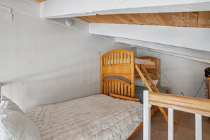 A small, single-bed room with a sloped ceiling and wooden headboard. - Steps to Heavenly | Mountain Chalet w/ Hot Tub (South Lake Tahoe)