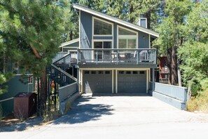Ein zweistöckiges Haus mit Balkon, Garage und überdachter Auffahrt.