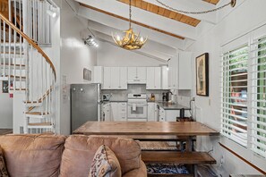 A modern kitchen with white cabinets, a wooden dining table, and a built-in oven. - Steps to Heavenly | Mountain Chalet w/ Hot Tub (South Lake Tahoe)