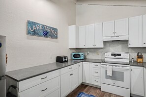 A kitchen with white cabinets, a toaster, a microwave, and an oven. - Steps to Heavenly | Mountain Chalet w/ Hot Tub (South Lake Tahoe)