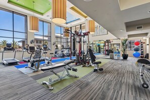 A gym with various exercise equipment, large windows, and a view of the outside. - Luxury Midtown Stay • Pool • Hot Tub • Near Downtown • King Bed (Phoenix)