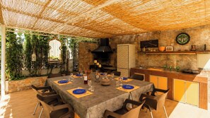 An outdoor dining area with a table set for four, surrounded by chairs. - La Luna Albolote by Ruralidays (Granada)