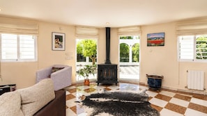 A living room with a fireplace, a sofa, a rug, and a view of the outdoors. - La Luna Albolote by Ruralidays (Granada)