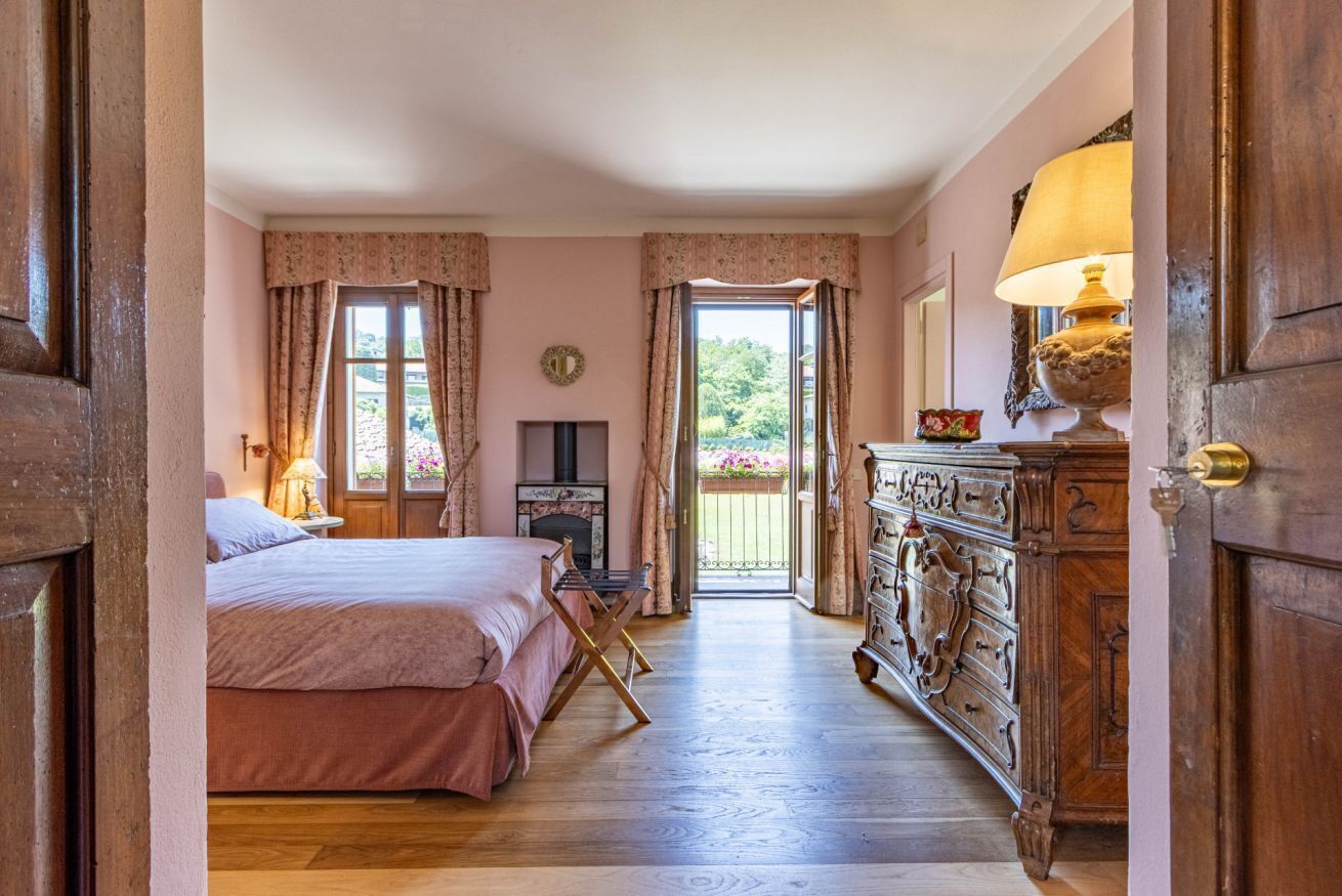Een slaapkamer met een bed, een kaptafel en uitzicht op het landschap.