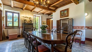 A dining room with a wooden table, chairs, and a chandelier.