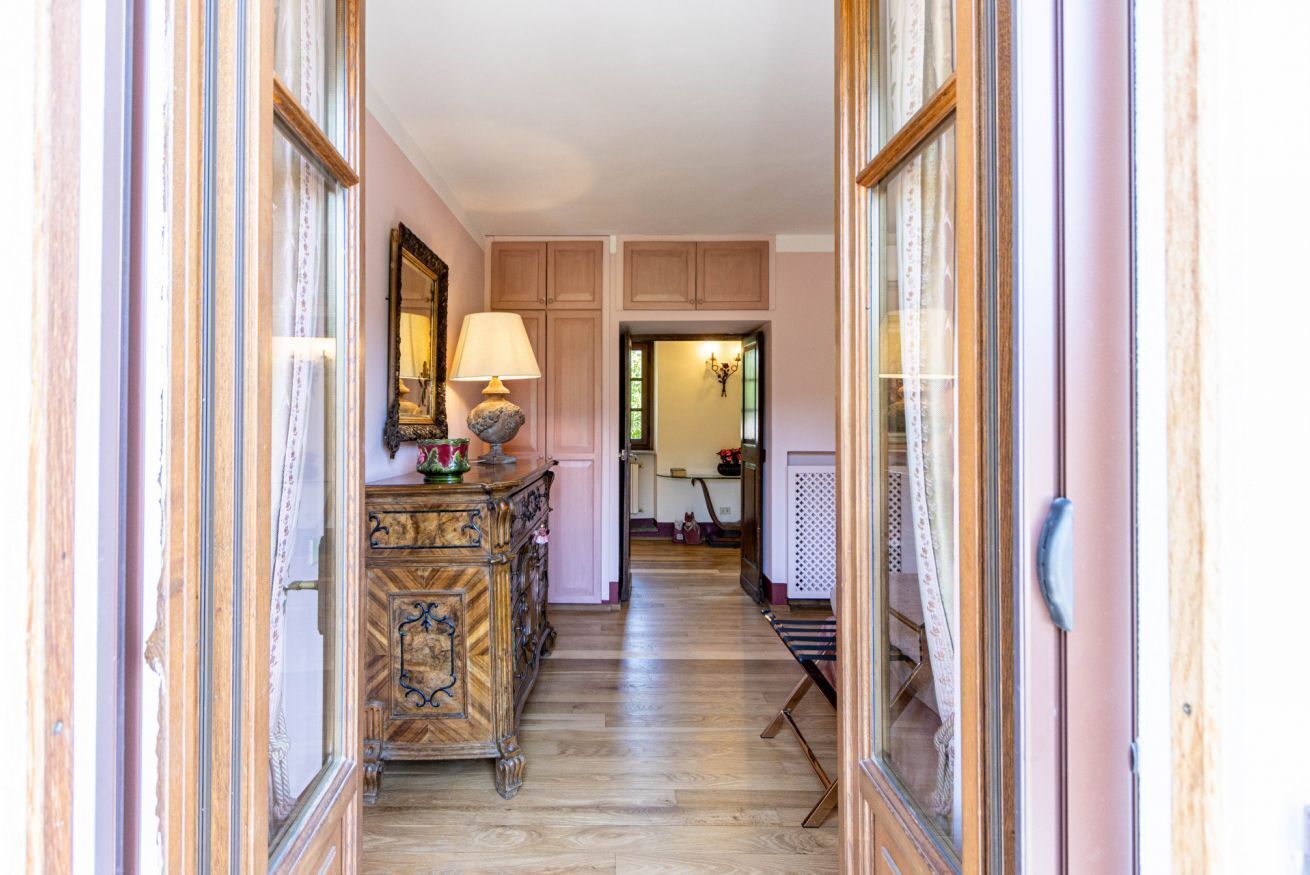 Un couloir avec des armoires en bois, un miroir et une lampe.