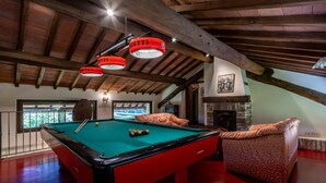 Een biljarttafel met een groene viltkleed, een pooltafel met rode en zwarte ballen en een strikband met rode en witte banen.