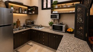 Una cocina moderna con armarios oscuros, un refrigerador de acero inoxidable, un microondas y un horno empotrado.