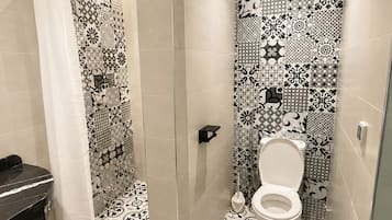 A bathroom with a shower, toilet, and sink.
