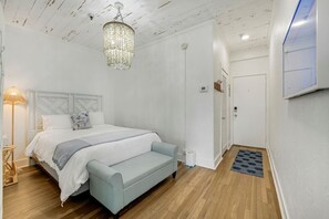 Une chambre à coucher avec un lit, une lampe de chevet et un lustre.