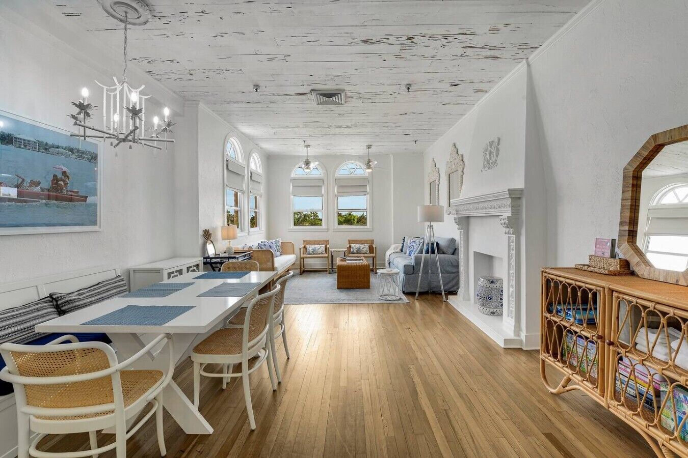 A spacious room with a dining area, a fireplace, and a view through large windows.