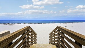 A wooden boardwalk leading to a beach with a clear view of the ocean. - Penthouse Paradise on Palm Beach Island (Palm Beach)