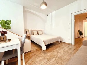 Ein modernes Schlafzimmer mit Bett, Nachttisch und Schreibtisch mit Stuhl.