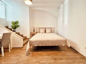 A bedroom with a bed, a desk, and a staircase. - Servus Homes - Roof Top Terrace - Super Central (Vienna)