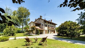 Un bâtiment en pierre doté d’un jardin, d’un espace extérieur aménagé pour s’asseoir et offrant une vue sur un ciel dégagé.