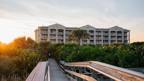 A hotel with a central courtyard, multiple balconies, and a wooden boardwalk leading to the entrance. - 2BR Villa at Holiday Inn Club Vacations Cape Canaveral Beach Resort (Cape Canaveral)