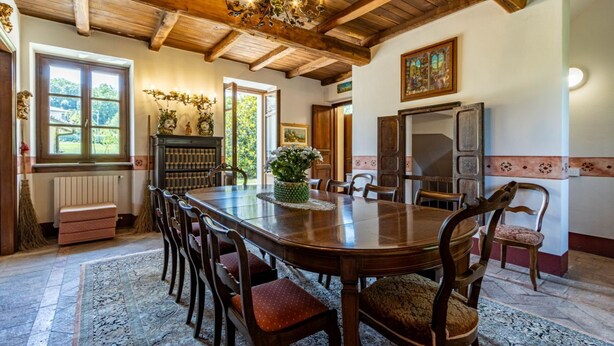 A dining area with a wooden table, chairs, and a chandelier. - Welcome to Villa Harmonia, a magnificent historic residence that has been carefully restored to preserve all the authentic charm of traditional Piedmontese farmhouses, combining elegance, comfort, and a timeless atmosphere.Nestled within more than 10,000 (Dormelletto)