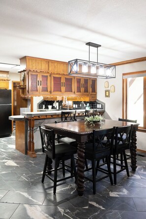 A kitchen with wooden cabinets, a marble floor, and a dining table with chairs. - 3 bed/2 bath Home- Livestock Facilities Available (Vici)