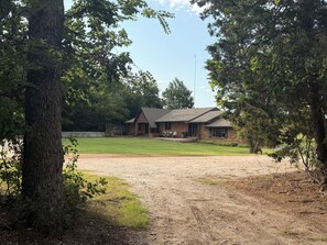 A house with a large lawn, a gravel driveway, and a wooden fence. - 3 bed/2 bath Home- Livestock Facilities Available (Vici)