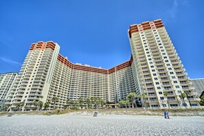 Ein großes, mehrstöckiges Hotel mit geschwungener Fassade in Strandnähe.