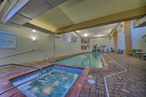 Une piscine intérieure avec un jacuzzi, un revêtement de sol carrelé et un panneau indiquant les règles d’utilisation du jacuzzi.