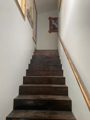 A wooden staircase with a handrail, leading to a landing with framed pictures on the walls. - Beautiful Mountain Home with Hot Tub (Silverton)