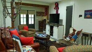A living room with a sofa, armchair, coffee table, and a television. - Welcome to Southern ReBelle! Walk to campus for game days or relax by the pool (Oxford)