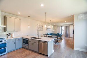 A modern kitchen with a central island, stainless steel appliances, and pendant lighting. - Luxury Stay Townhome in North Austin (Austin)