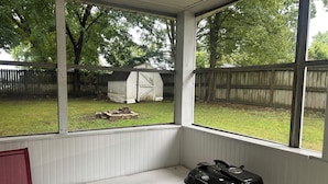 A covered outdoor seating area with a grill on a stand. - Comfortable Charming Convenient in Covington TN (Covington)