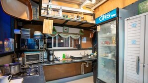 Cocina compacta con refrigerador, microondas y cafetera.