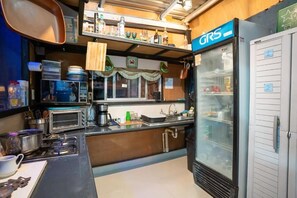 A compact kitchen with a refrigerator, microwave, and a coffee maker.