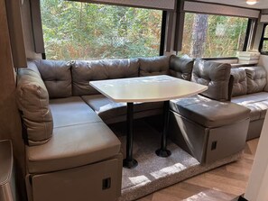 A cozy interior with a sectional sofa, a small table, and a view of the outdoors.