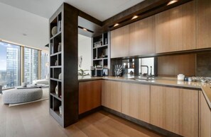 Eine moderne Küche mit Holzschränken, einer integrierten Kücheninsel und einem großen Fenster mit Blick auf eine Skyline.