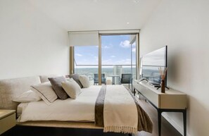 A hotel room with a bed, a TV, a window with a city view, and a balcony. - Luxury London Apartment With 3 Bedrooms (London)
