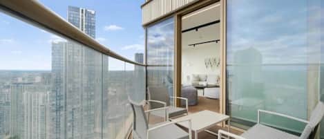 Un balcon avec vue sur la ville, un coin salon et un aperçu de l’intérieur.