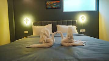 A hotel room with a bed, two wall-mounted light fixtures, and a painting on the wall.
