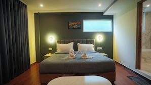 A hotel room with a large bed, two wall-mounted lamps, a flat-screen TV, and a painting on the wall. - Meraki Hotels & Resorts Sikkim (Gangtok)