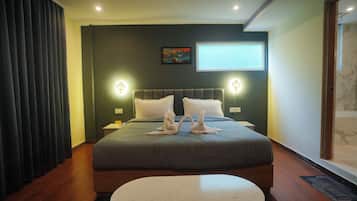Habitación de hotel con una cama grande, dos lámparas fijadas a la pared, un televisor de pantalla plana y un cuadro en la pared.